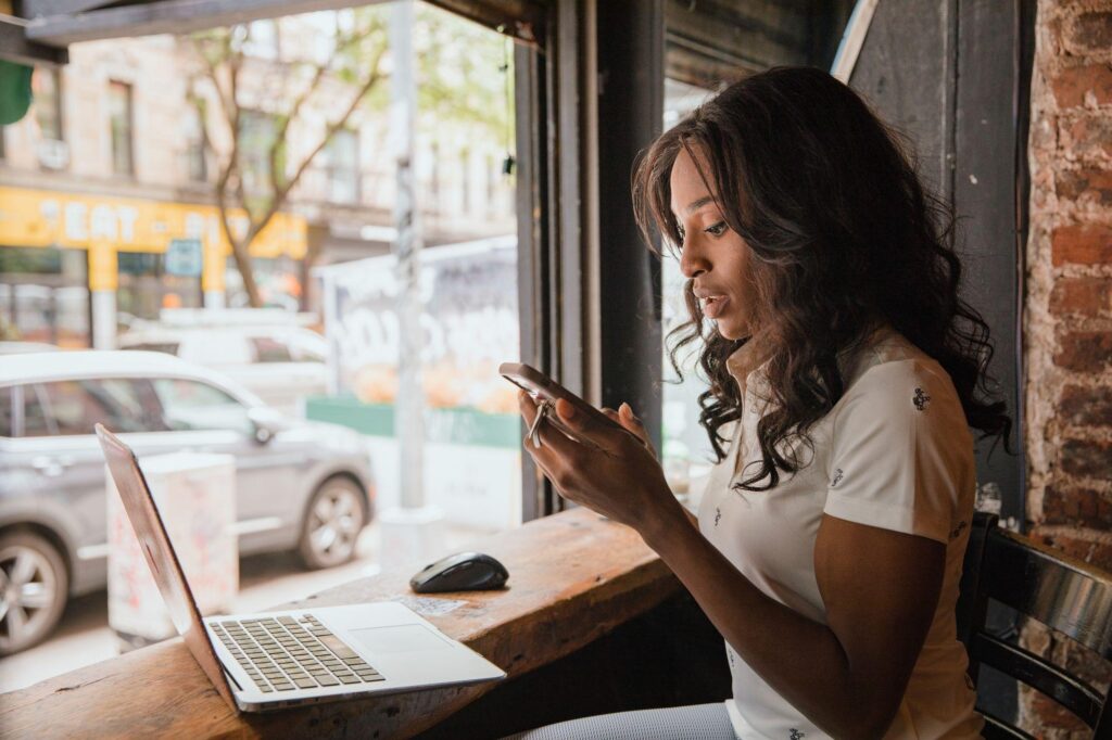 BYOD Policy: 14 Essential Questions Before You Say Yes 2 Woman using a personal laptop and smartphone at a cafe