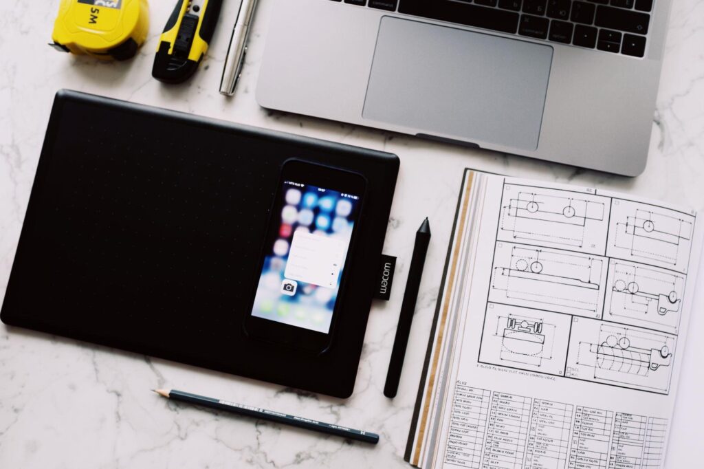 Laptop, phone, and smart devices on a desk in a workplace